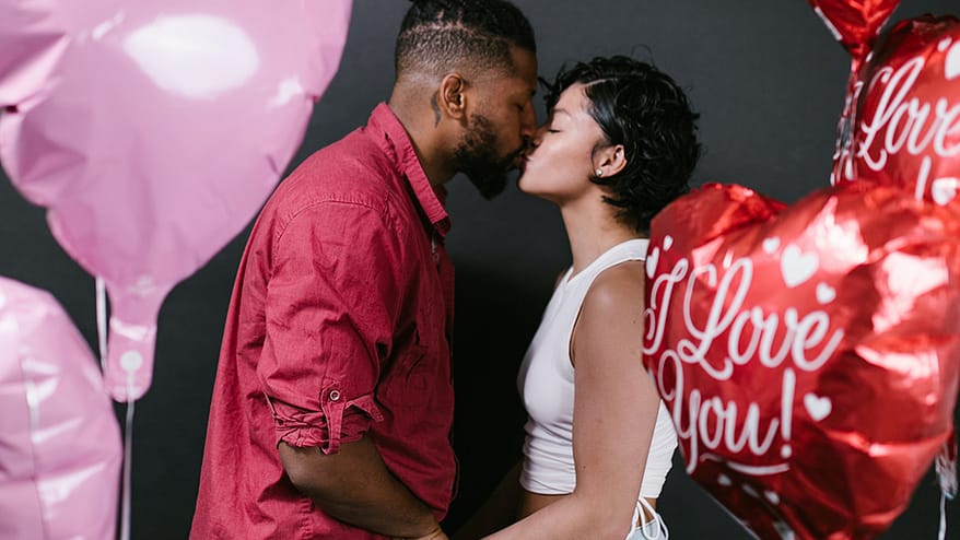 couple kissing surrounded by balloons